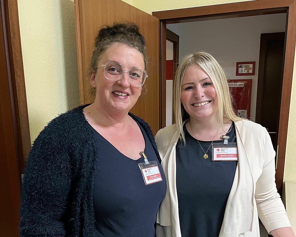 Zwei Mitarbeiterinnen des FHZ von einer Tür