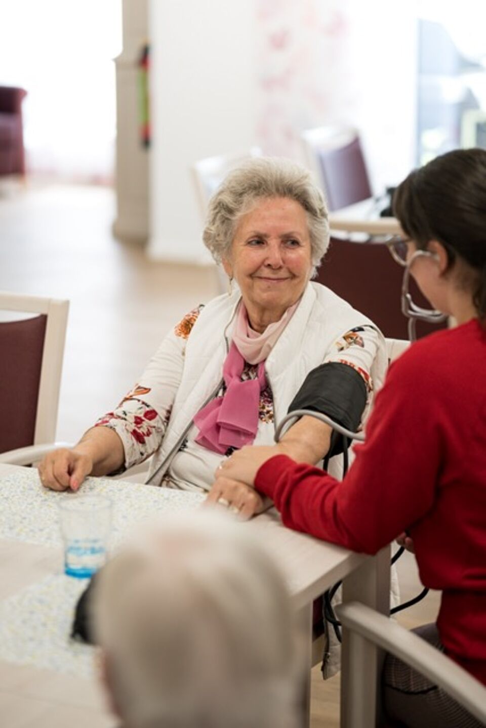 Pflegefachfrau misst Blutdruck
