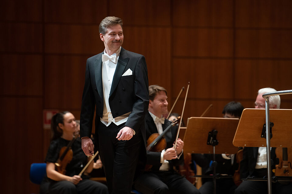 Sänger, im Hintergrund Orchester