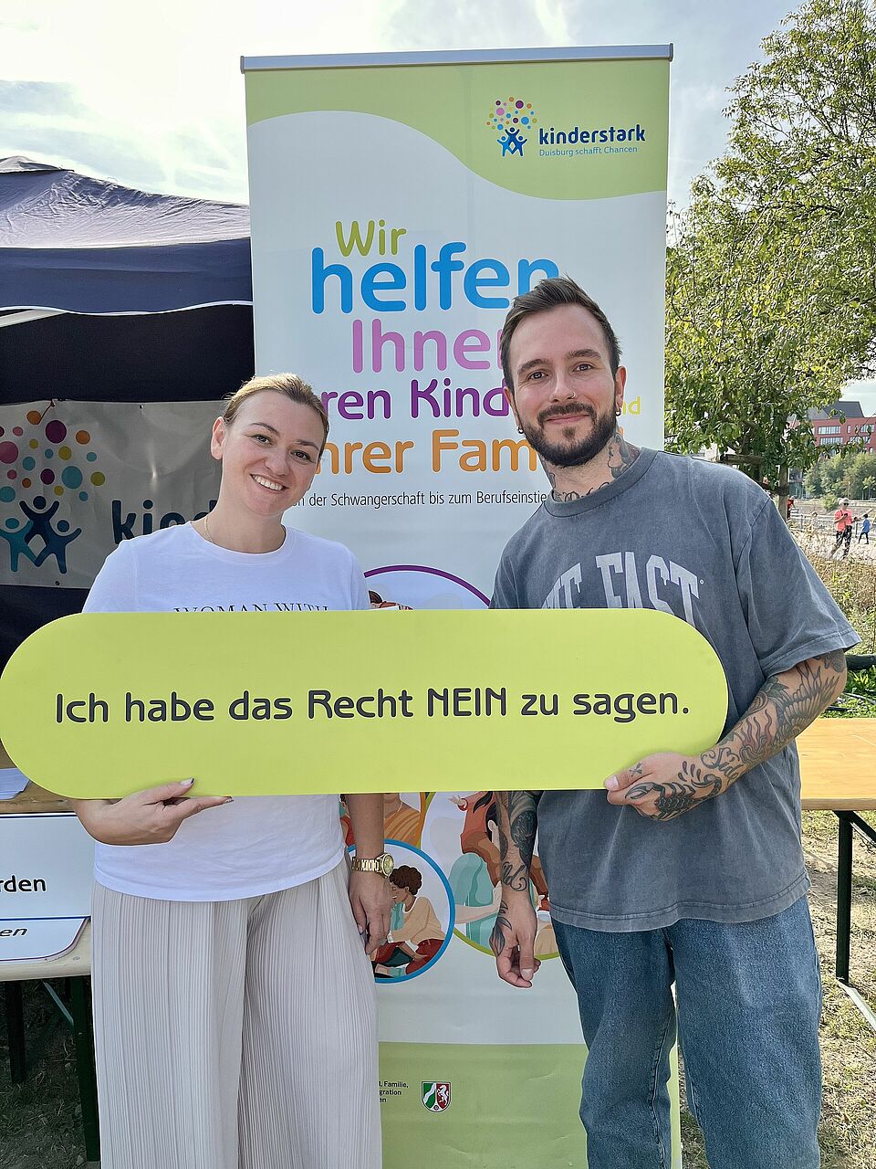 Zwei Personen halten ein Schild hoch